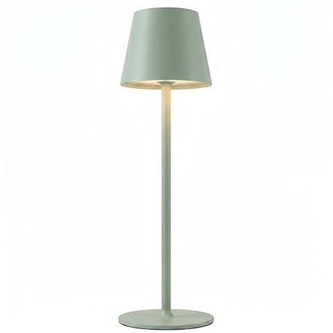 Lampe de table verte à abat-jour rond posée sur une table en bois, dans une lumière douce