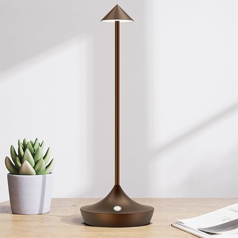 Lampe de table en aluminium marron posée sur une table en pierre dans une lumière douce de fin de journée.