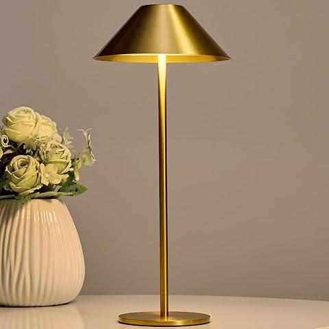 Lampe de table LED Bojim en métal doré, posée sur une table de pierre au crépuscule.