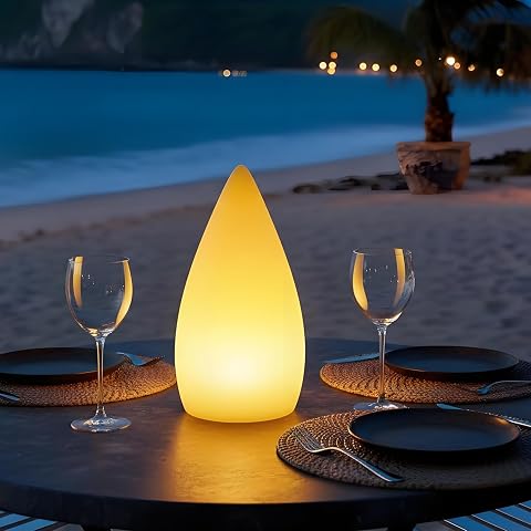 Lampe de table blanche en forme de goutte, posée sur une table en bois à la lumière du soir
