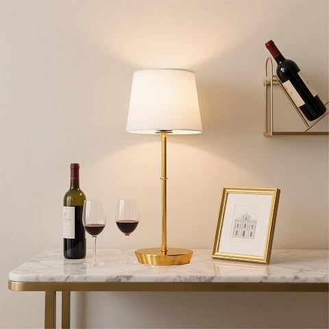 Lampe de chevet sans fil au fini laiton et abat-jour en tissu, posée sur une table en bois.
