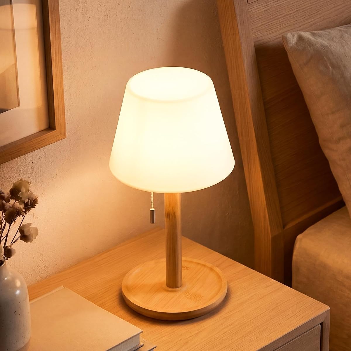 Lampe de table blanche sans fil avec pied en bambou naturel, posée sur une table en bois