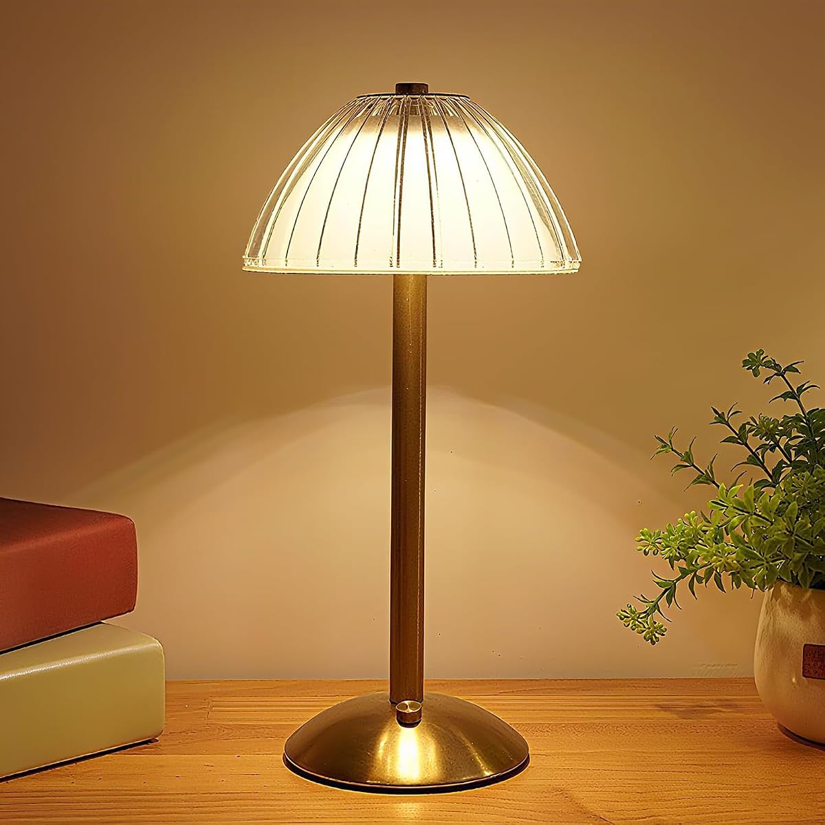 Lampe de table dorée avec abat-jour en acrylique, posée sur une table en bois