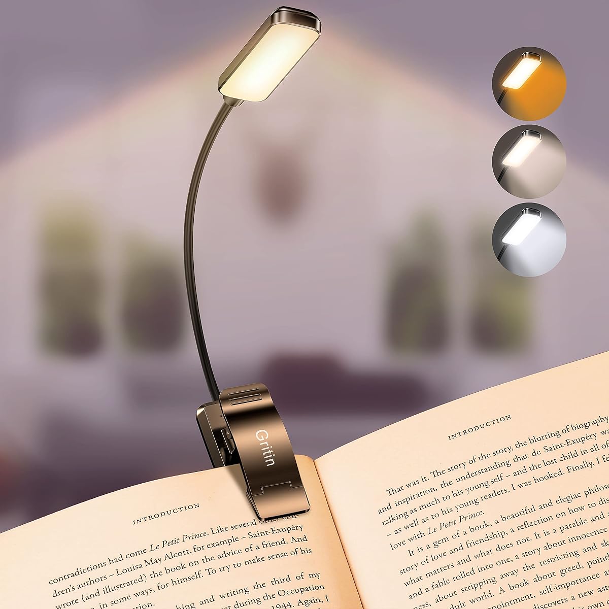 Lampe de lecture noire à pince avec col flexible, fixée à un livre ouvert sur une table en bois.